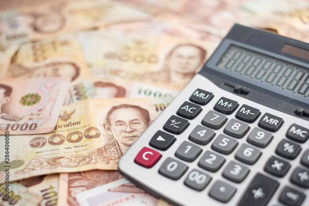 1000 Thai Baht banknote background with Calculator. business, investment, retirement planning, finance and Saving for the future concepts 1000 Thai Baht banknote background with Calculator. business, investment, retirement planning, finance and Saving for the future concepts