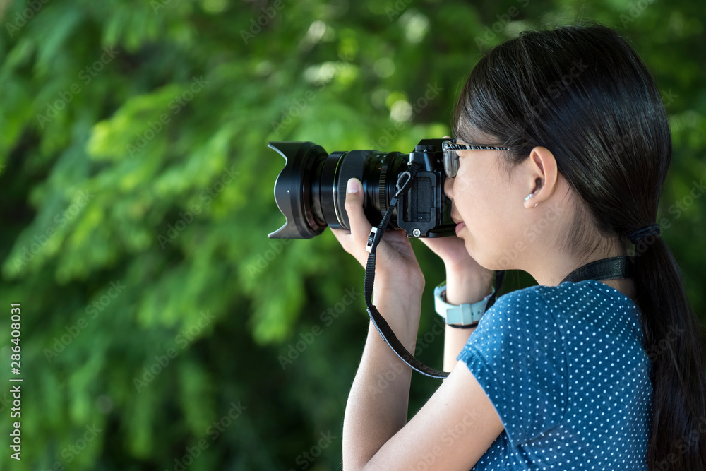 Young little girl photographer with a digital camera taking photo outdoors Young little girl photographer with a digital camera taking photo outdoors