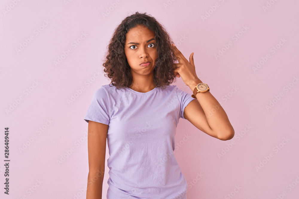 Young brazilian woman wearing t-shirt standing over isolated pink background Shooting and killing oneself pointing hand and fingers to head like gun, suicide gesture. Young brazilian woman wearing t-shirt standing over isolated pink background Shooting and killing oneself pointing hand and fingers to head like gun, suicide gesture.