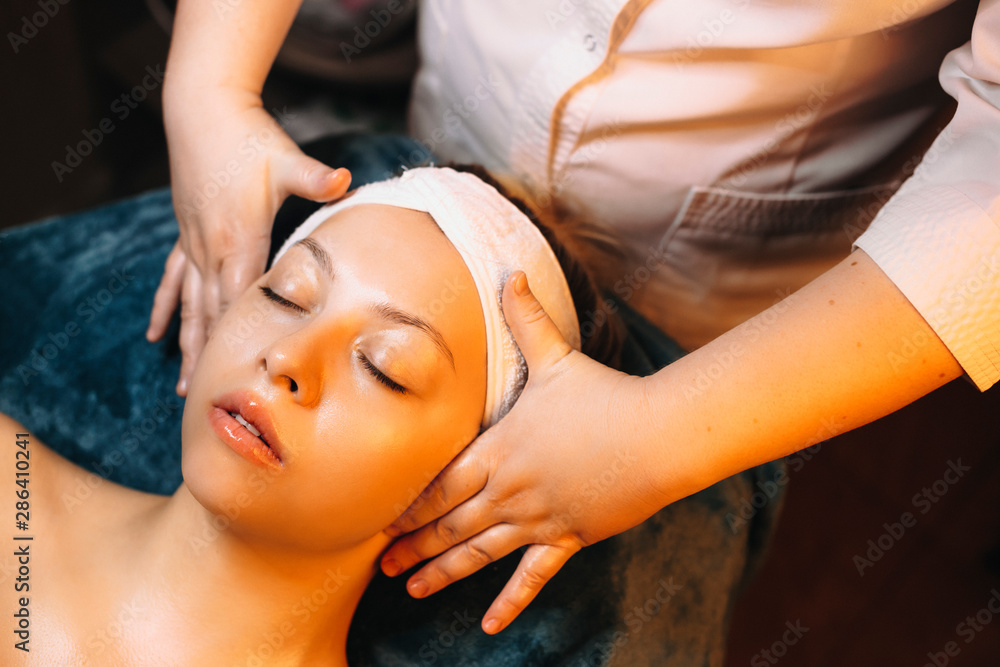 Upper view of a charming woman doing facial therapy in a wellness spa resort.