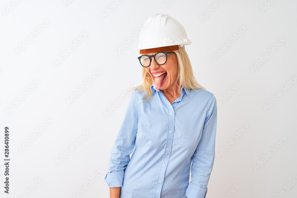Middle age architect woman wearing glasses and helmet over isolated white background sticking tongue out happy with funny expression. Emotion concept. Middle age architect woman wearing glasses and helmet over isolated white background sticking tongue out happy with funny expression. Emotion concept.