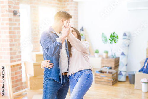 Beautiful young couple having fun dancing at new apartment, celebrating moving to a new home
