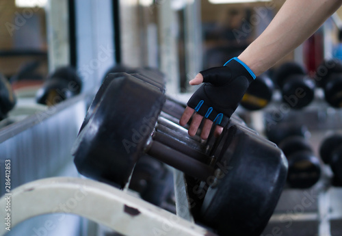 Close up hand taking heavy rusty dumbbell to exercise for strength training. sport, fitness, health, lifestyle and people concept