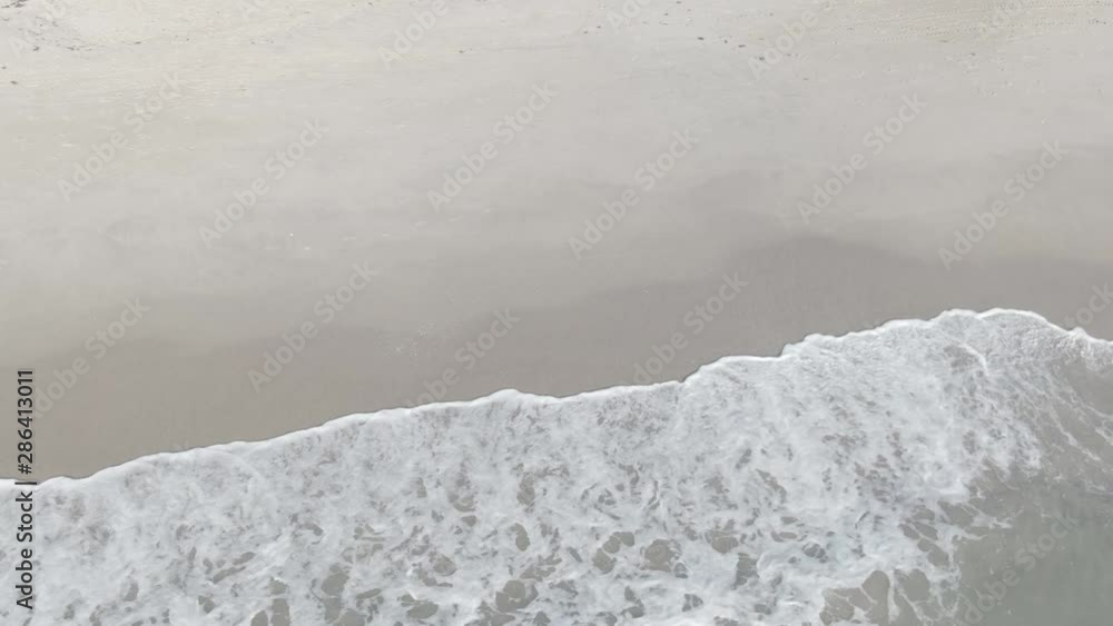 Waves on White Sand Beach. Aerial View of Ocean water splashing on sand shore. Waves on White Sand Beach. Aerial View of Ocean water splashing on sand shore.