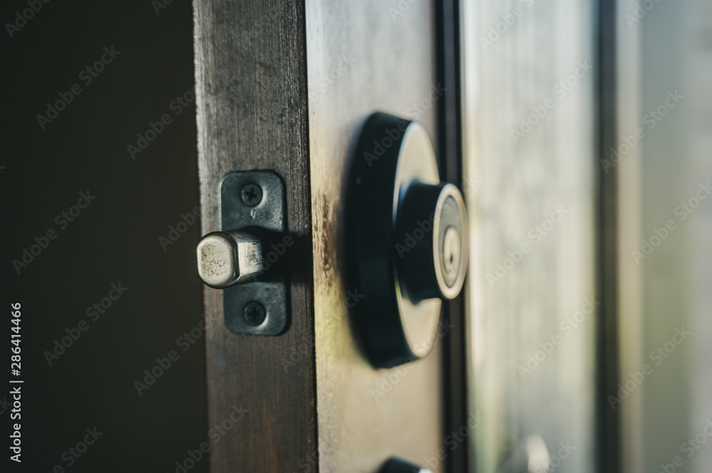 Deadbolt on wooden door engaged with bolt extended Deadbolt on wooden door engaged with bolt extended