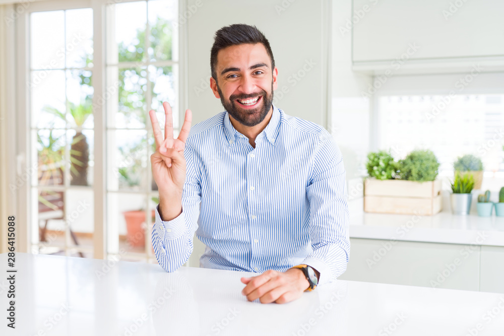Handsome hispanic business man showing and pointing up with fingers number three while smiling confident and happy.