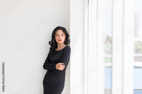 Asian model woman posing near big windows..