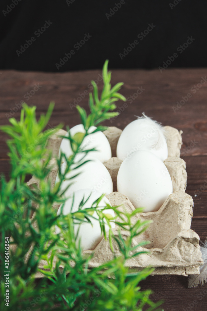 White chicken eggs and shell on a dark wooden background. White chicken eggs and shell on a dark wooden background.