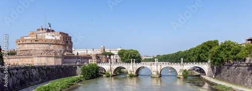 Panoramic view of Ponte Sant'Angelo and Castel Sant'Angelo - Rome, Italy. Tourist boat passes under Ponte Sant'Angelo.