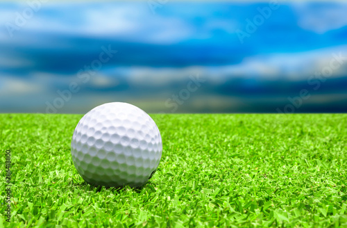 Golf ball on tee with blue sky