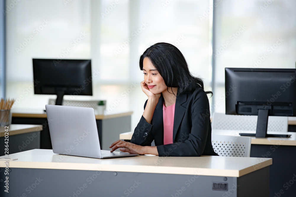 Asian businesswoman using notebook computer.. Asian businesswoman using notebook computer..