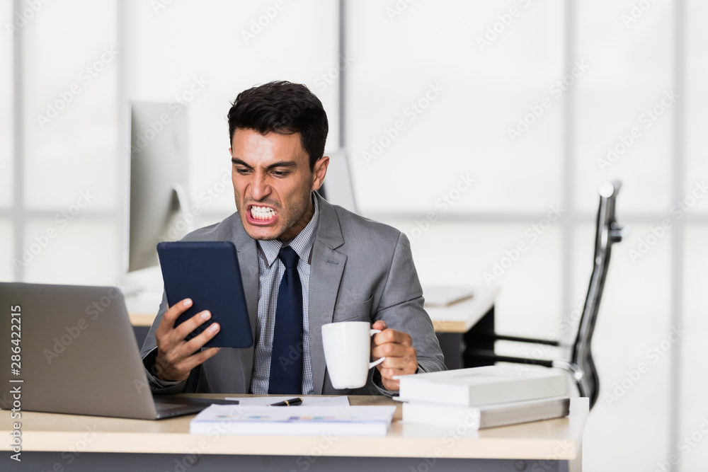 Businessman uses tablet computer, drinking coffee.. Businessman uses tablet computer, drinking coffee..
