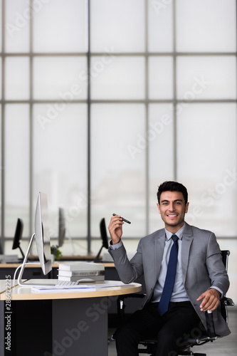Businessman writing report in modern office..