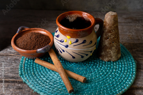 mexican cup of coffee with cinnamon on wooden background photo