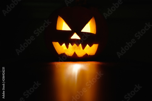 Wallpaper Mural Halloween October holiday celebration symbol, scary pumpkin glowing with reflection, black background Torontodigital.ca