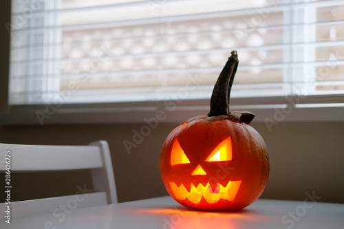 Wallpaper Mural Halloween October holiday celebration symbol, scary pumpkin on kitchen table glowing from inside Torontodigital.ca