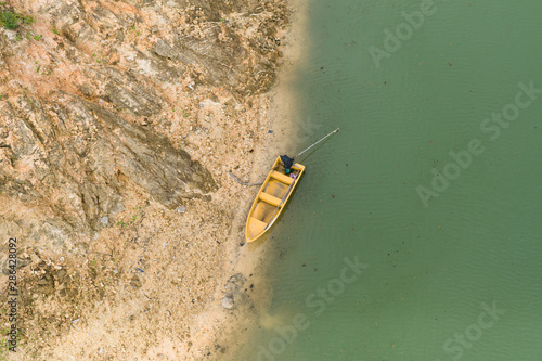 The yellow boat is parked on the green water shore.