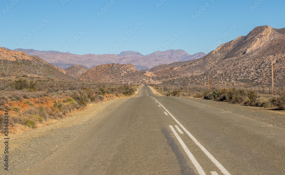A motorway leads through an arid landscape to the hills image in landscape format with copy space A motorway leads through an arid landscape to the hills image in landscape format with copy space
