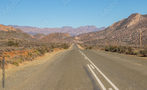 A motorway leads through an arid landscape to the hills image in landscape format with copy space
