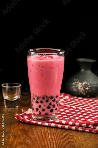 Bubble milk tea with milk  and bubble topping for tea or other beverage on the wood table with copy-space for text.