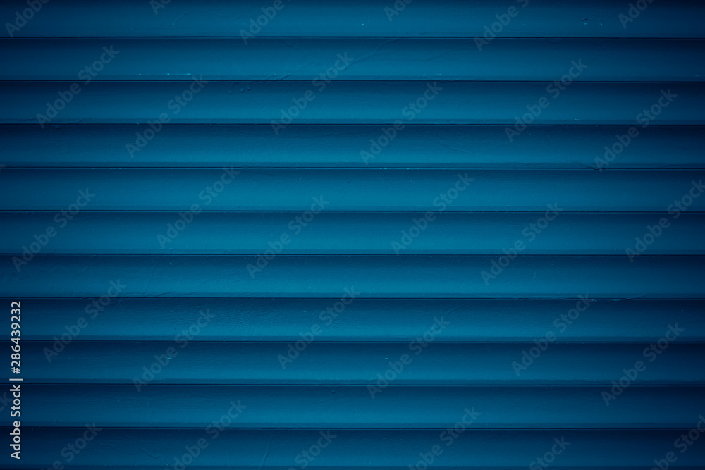 Texture of dark blue metal jalousie. Ribbed background with stripes, straight lines. Modern backdrop of striped fence. Texture of dark blue metal jalousie. Ribbed background with stripes, straight lines. Modern backdrop of striped fence.