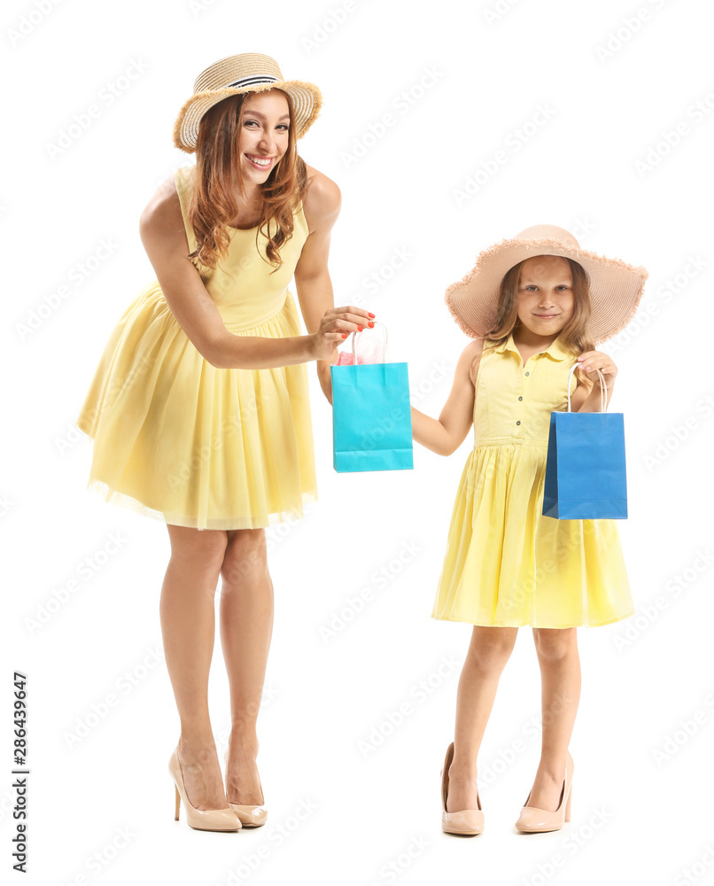 Portrait of beautiful woman and her little daughter with shopping bags on white background Portrait of beautiful woman and her little daughter with shopping bags on white background