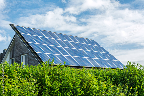Bild auf Leinwand House with solar panels on the roof on a sunny day