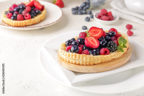 Sweet tartlet with berries on light table