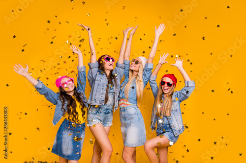Photo of beautiful crazy little victorious excited having fun pretty mothers and daughters raising fists up in air enjoying delight isolated yellow background