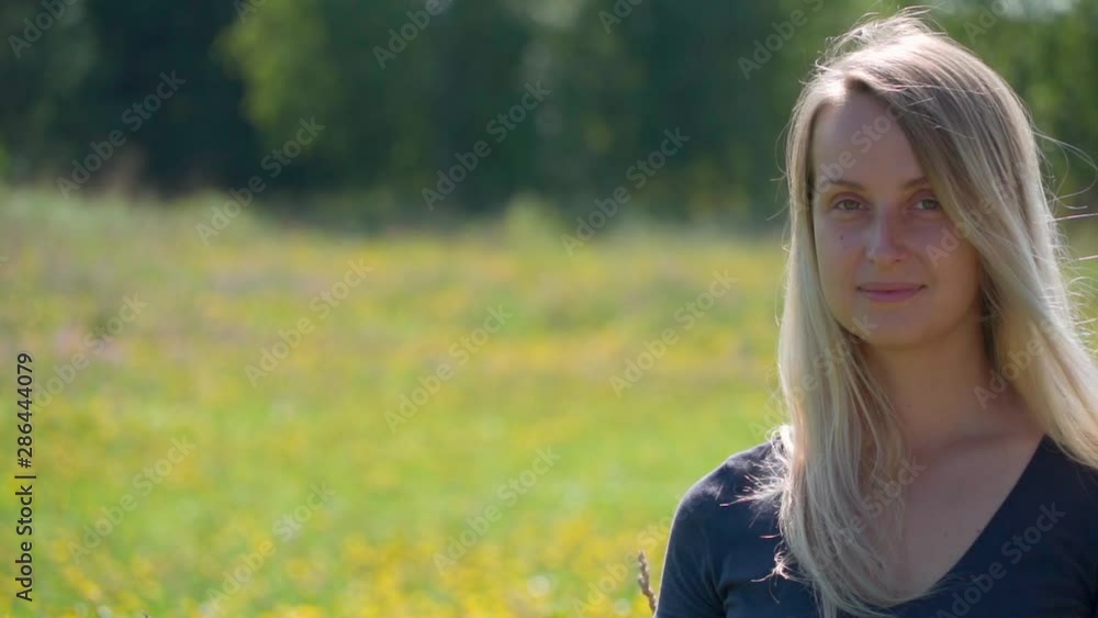 Young beautiful girl posing in the blooming field Young beautiful girl posing in the blooming field
