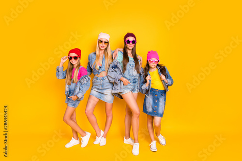 Full body photo of four beautiful attractive pretty charming confident streetstyle denim apparel fans standing isolated over bright shiny background
