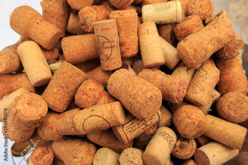 A glass bowl containing a multitude of wine corks - Image