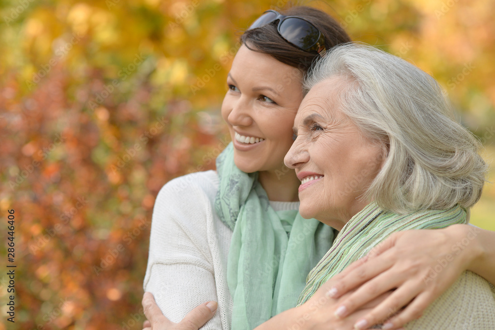 Fototapeta premium Portrait of senior woman with adult daughter in autumnal park