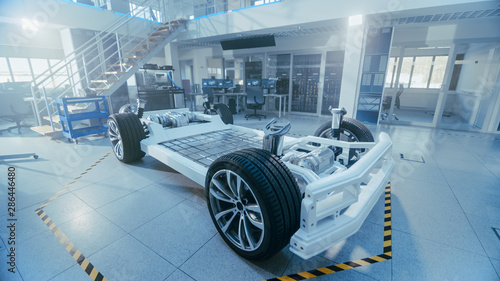 Concept of Authentic Electric Car Platform Chassis Prototype Standing in High Tech Industrial Machinery Design Laboratory. Hybrid Frame include Tires, Suspension, Engine and Battery.  © Gorodenkoff