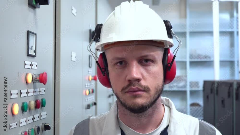 handsome engineer stands near hydropack system panel handsome engineer stands near hydropack system panel