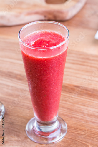 Fresh delicious strawberry juice drink with dark red color in a tall glass