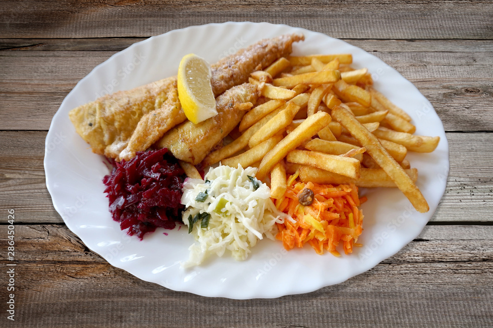 Fried fish - zander/ sander/ pikeperch, salad and french fries on plate Fried fish - zander/ sander/ pikeperch, salad and french fries on plate