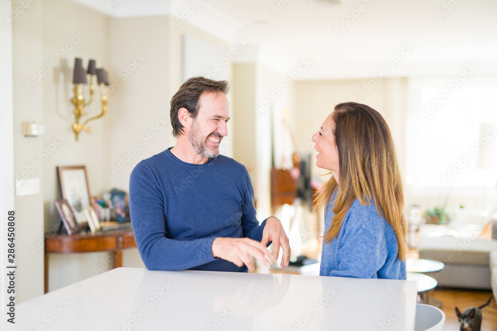 Romantic middle age couple sitting together at home Romantic middle age couple sitting together at home