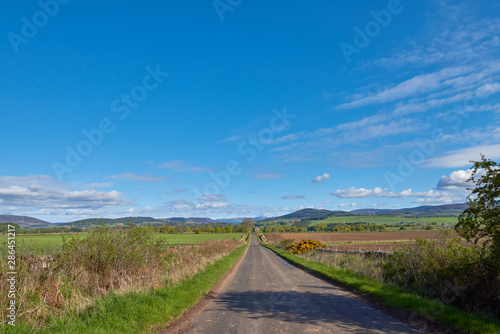 Looking towards Glen Prosen in the Angus Glens from a small minor straight road, heading towards Inverharity Castle on a sunny Morning in May.