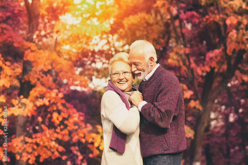 Portrait of senior couple, husband hugging kissing his wife in cheek Portrait of senior couple, husband hugging kissing his wife in cheek