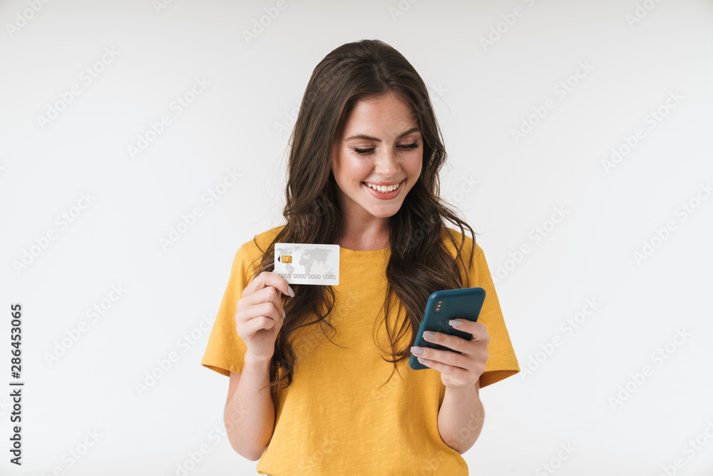 © Drobot Dean - Image of gorgeous brunette woman wearing casual clothes holding credit card and cellphone