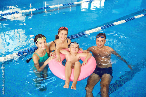 A happy family swims in a swimming pool indoors. © Studio Romantic