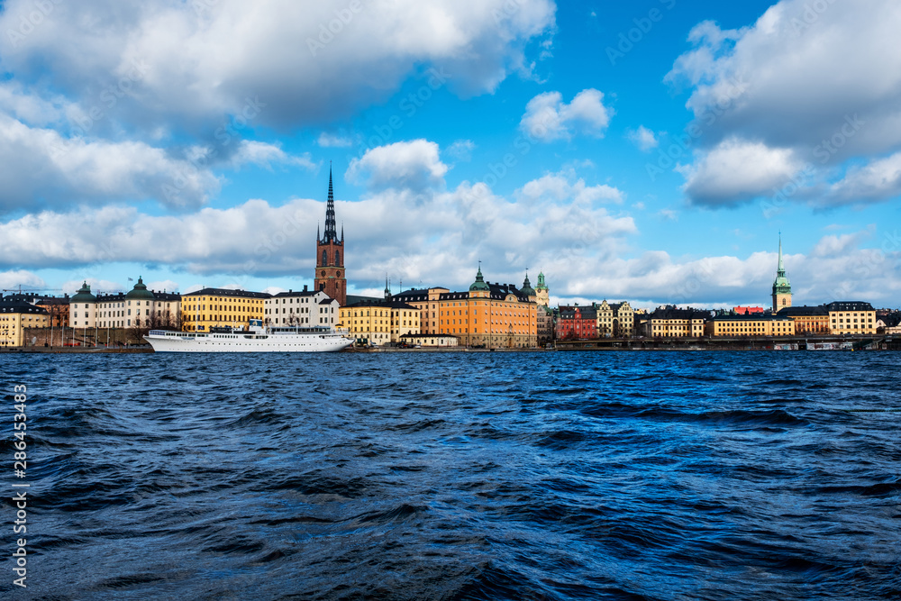 View of Gamla Stan in Stockholm, Sweden with landmarks like Riddarholm Church during the cloudy and sunny day