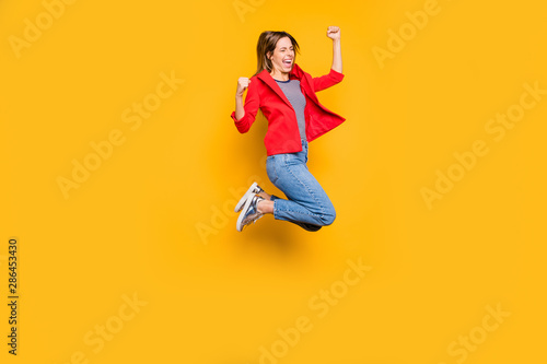 Full length photo of cheerful person raising her fists screaming yeah isolated over yellow background © deagreez