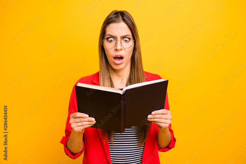 Portrait of astonished hipster holding printed book screaming shouting wearing eyeglasses eyewear isolated over yellow background Portrait of astonished hipster holding printed book screaming shouting wearing eyeglasses eyewear isolated over yellow background