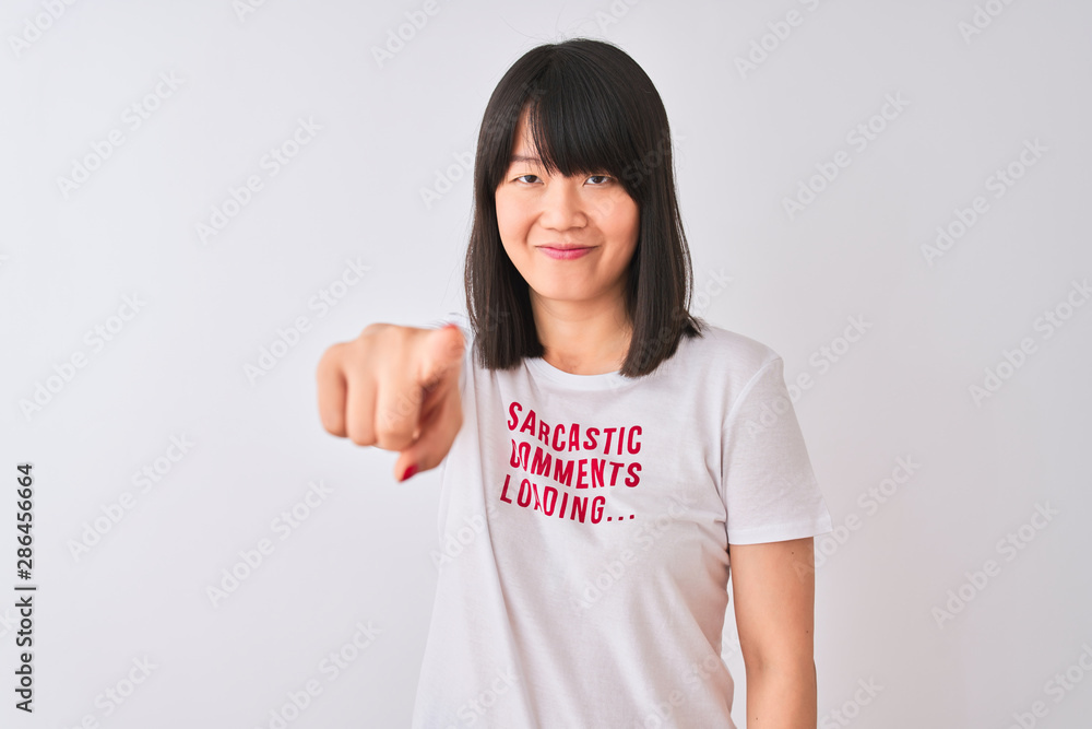 Young beautiful Chinese woman wearing fanny t-shirt over isolated white background pointing with finger to the camera and to you, hand sign, positive and confident gesture from the front Young beautiful Chinese woman wearing fanny t-shirt over isolated white background pointing with finger to the camera and to you, hand sign, positive and confident gesture from the front