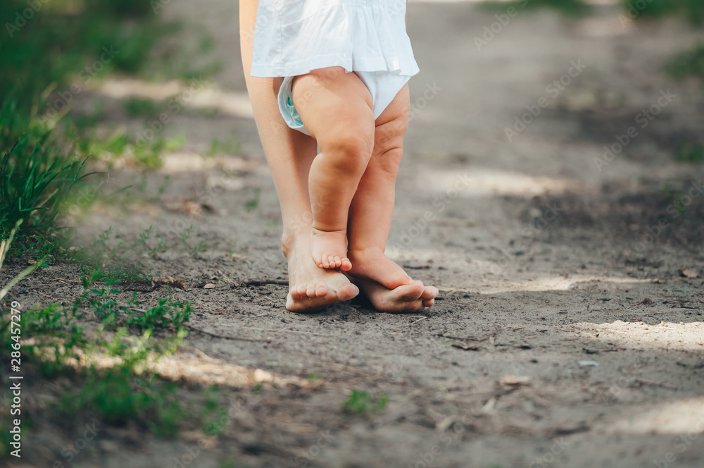 Little baby does his first steps outdoors.