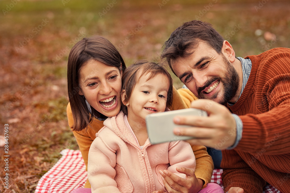 Happy family taking selfie, posing for photo.