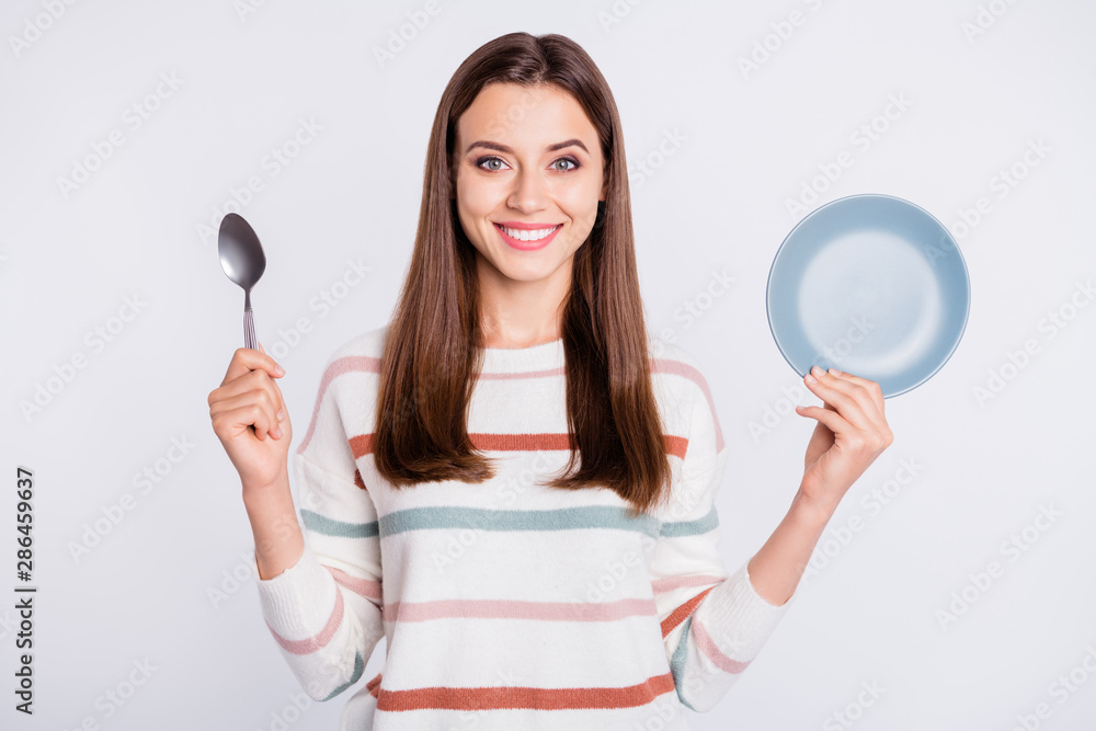 Hungry lady holding spoon and empty plate ready for dinner wear striped pullover isolated white background Hungry lady holding spoon and empty plate ready for dinner wear striped pullover isolated white background