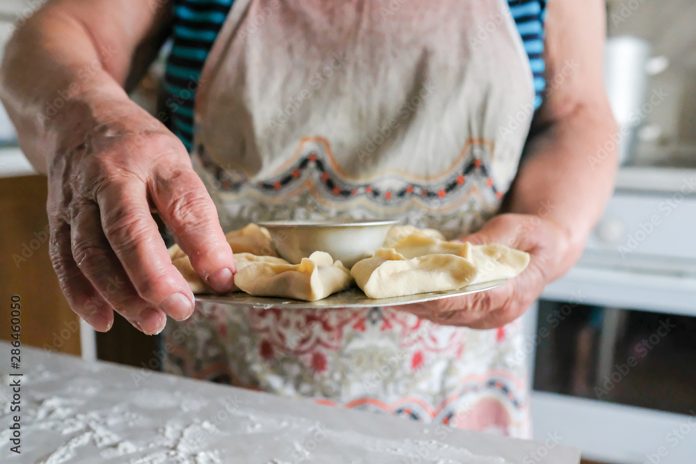 Special device for cooking dough. Preparing manti, a dish of dough. Lay down portioned dumplings
